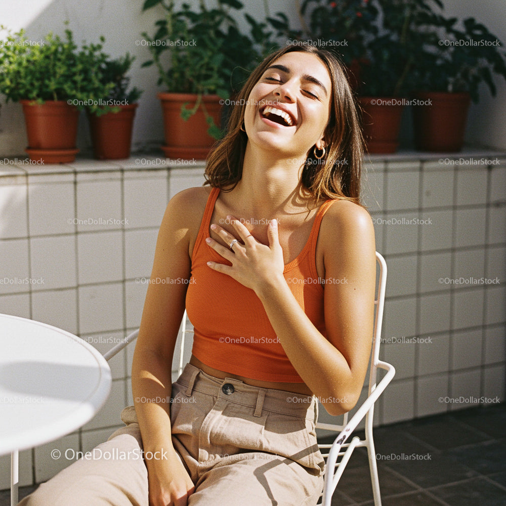 Smiling Woman in Orange Top Sitting Outdoors