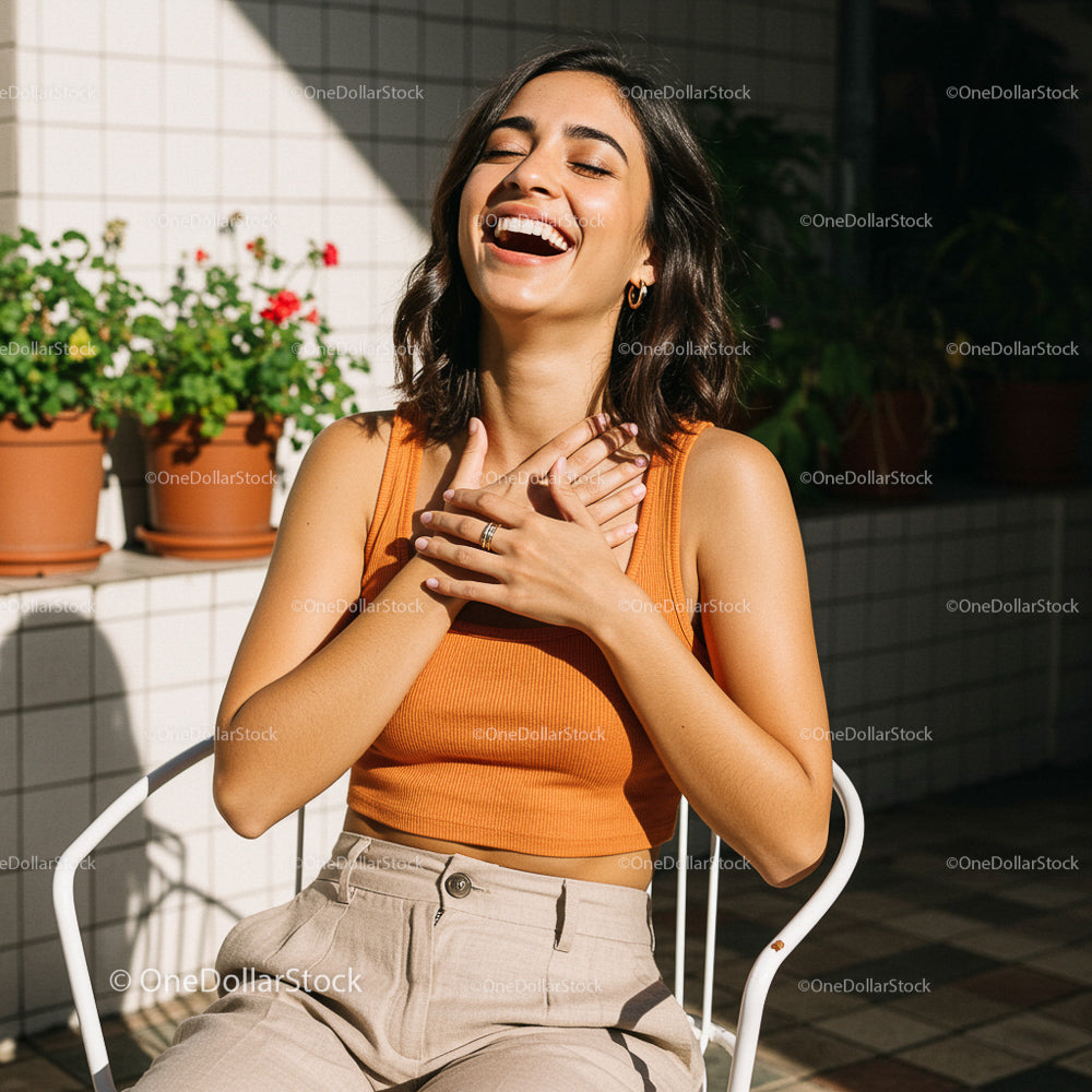 Woman Laughing in Sunlit Garden with Potted Plants
