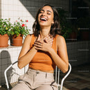 Woman Laughing in Sunlit Garden with Potted Plants