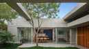 Modern Concrete Structure with Outdoor Dining and Tree Canopy