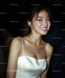 Elegant Woman in White Dress with Gold Jewelry Smiling