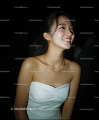 Smiling Woman in White Evening Gown with Gold Jewelry