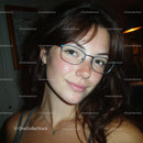 Smiling Woman with Glasses and Freckles in Soft Lighting