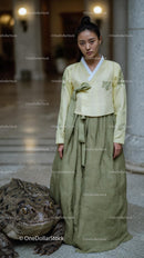 Woman in Hanbok with Large Toad in Serene Setting