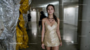 Elegant Woman in Gold Dress at Art Gallery