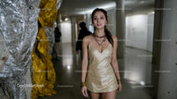 Elegant Woman in Gold Dress at Art Gallery