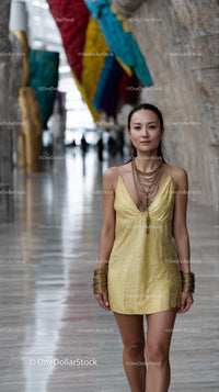 Stylish Woman in Yellow Dress with Art Installation Background