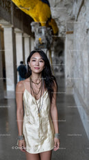 Stylish Woman in Golden Dress with Luxurious Parrot Sculpture