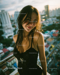 Confident Woman in Black Dress Overlooking City Skyline