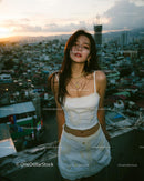 Stylish Woman on Rooftop with Urban Sunset Skyline
