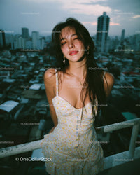 Woman in Summer Dress on Rooftop with Cityscape Backdrop