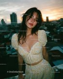 Woman in Floral Dress Posing on Rooftop at Sunset