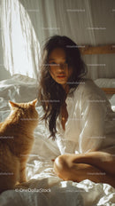 Woman Relaxing with Ginger Cat in Sunlit Bedroom