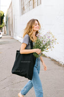 Smiling Woman Walking with Wildflower Bouquet on Urban Street