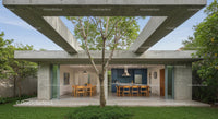Modern Concrete Structure with Outdoor Dining and Tree Canopy