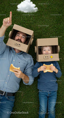 Father and Son Playfully Dreaming in Cardboard Helmets