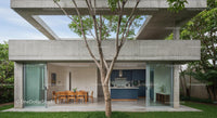 Modern Concrete Structure with Outdoor Dining and Tree Canopy