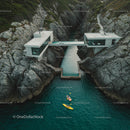 Modern Cliffside House with Kayakers on Turquoise Waters