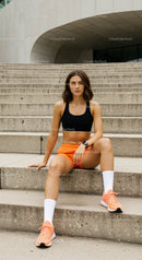 Athletic Woman Resting on Urban Stairs in Sporty Outfit