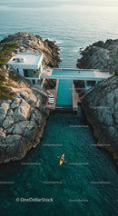Luxury Cliffside Home with Kayakers on Turquoise Waters