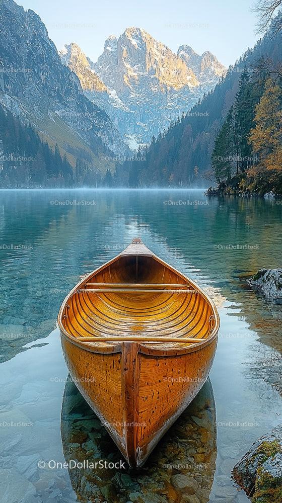 Wooden Canoe on Calm Alpine Lake in Misty Mountain Landscape