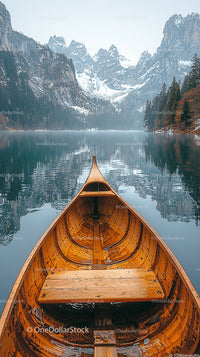 Wooden Canoe on Tranquil Mountain Lake with Snowy Peaks