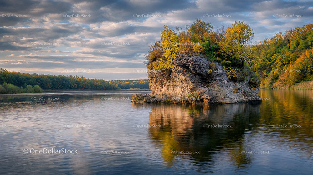 Rocky Island with Autumn Foliage on a Calm Lake
