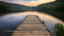 Tranquil Lake at Sunset with Wooden Pier and Forest View
