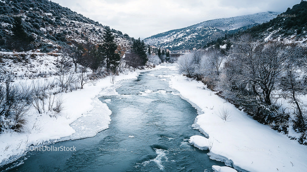 Scenic Winter River Flowing Through Snowy Mountain Landscape