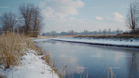 Frozen River and Snowy Landscape Under Clear Blue Sky