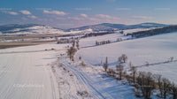Aerial View of Snow-Covered Rolling Hills in Winter