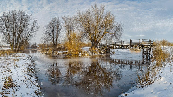 Tranquil Winter Landscape with Wooden Bridge Over Frozen River