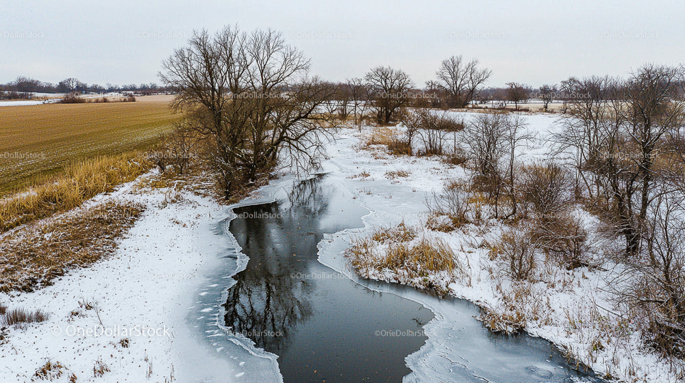 Frozen River Flowing Through Snowy Winter Landscape