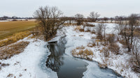 Frozen River Flowing Through Snowy Winter Landscape