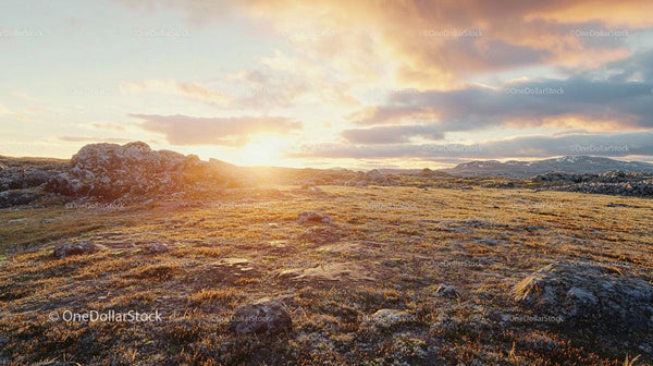 Golden Hour Over Rocky Terrain with Dramatic Sky
