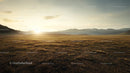 Serene Sunset over Expansive Grassland and Distant Mountains