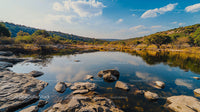 Tranquil River Scene with Rocky Bank and Reflective Waters