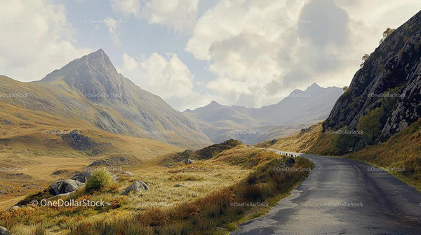 Scenic Mountain Road Surrounded by Majestic Peaks and Lush Hills