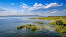 Idyllic Lake Landscape with Lush Greenery and Blue Sky