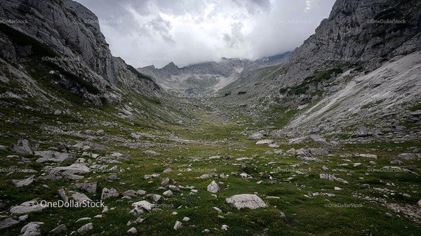 Majestic Mountain Valley with Dramatic Sky and Rugged Terrain