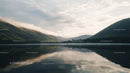 Misty Morning Over Tranquil Lake with Reflective Hills