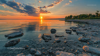 Serene Sunset Over Rocky Shoreline with Vibrant Sky
