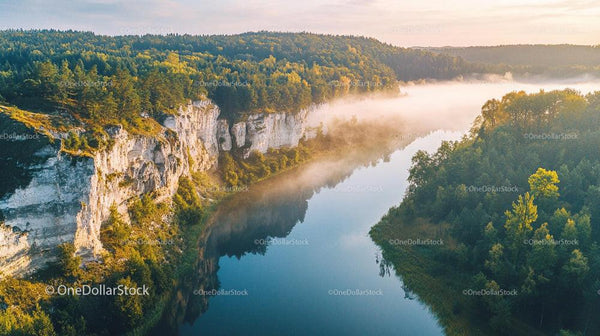Drone Aerial View of Misty River and Forested Cliffs at Sunrise