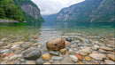 Tranquil Mountain Lake with Rocky Shoreline and Forested Cliffs