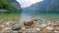 Tranquil Mountain Lake with Rocky Shoreline and Forested Cliffs