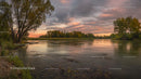 Tranquil River at Sunset with Vibrant Sky and Lush Trees