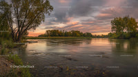 Tranquil River at Sunset with Vibrant Sky and Lush Trees