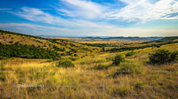 Expansive Rolling Hills Under a Bright Blue Sky