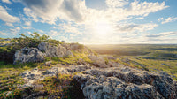 Sunlit Rocky Landscape Under a Dramatic Sky
