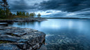 Dramatic Overcast Sky over Serene Lake and Rocky Shore